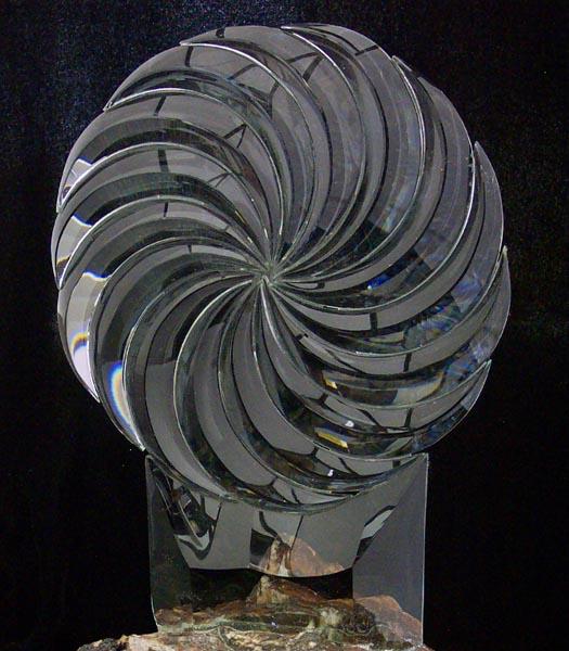A hand beveled cluster of swirl shaped pieces.